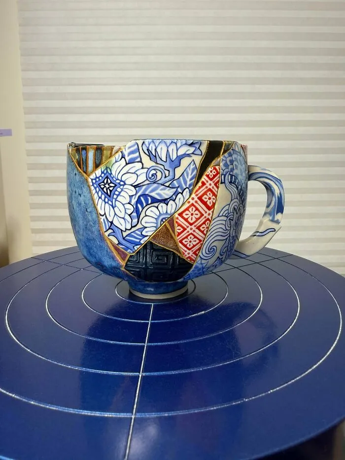 An ornate blue and white ceramic mug showcasing intricate pottery creations and kintsugi art