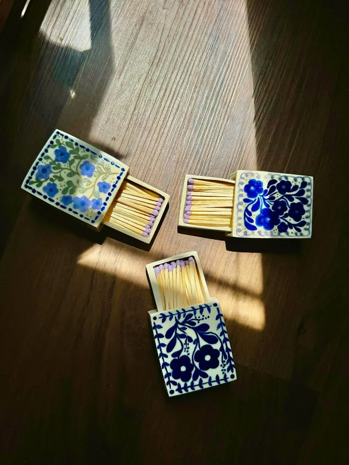 Three ceramic matchboxes decorated with blue floral patterns, part of unique pottery creations
