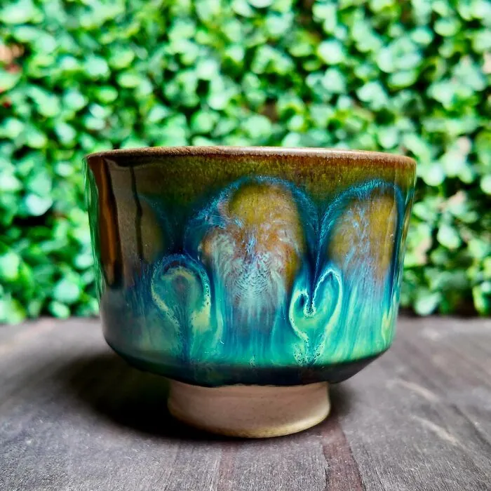 A handmade glazed ceramic cup displaying artistic pottery creations