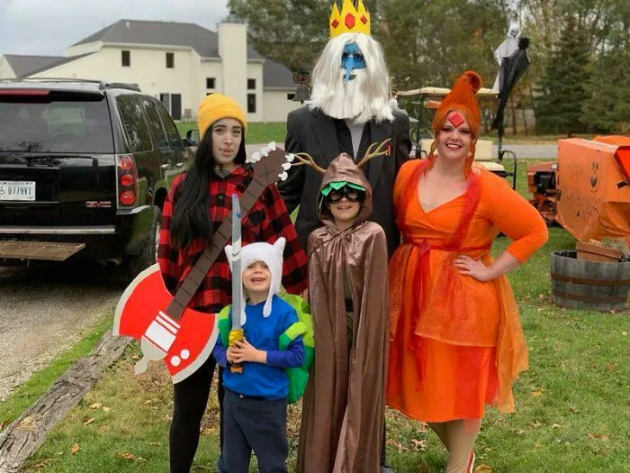 Group dressed up in Adventure Time kids Halloween costumes outdoors.