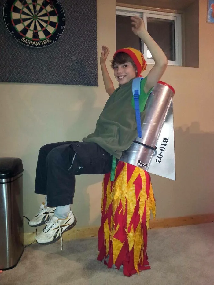 A boy wearing a homemade rocket jetpack optical illusion from creative kids Halloween costumes.