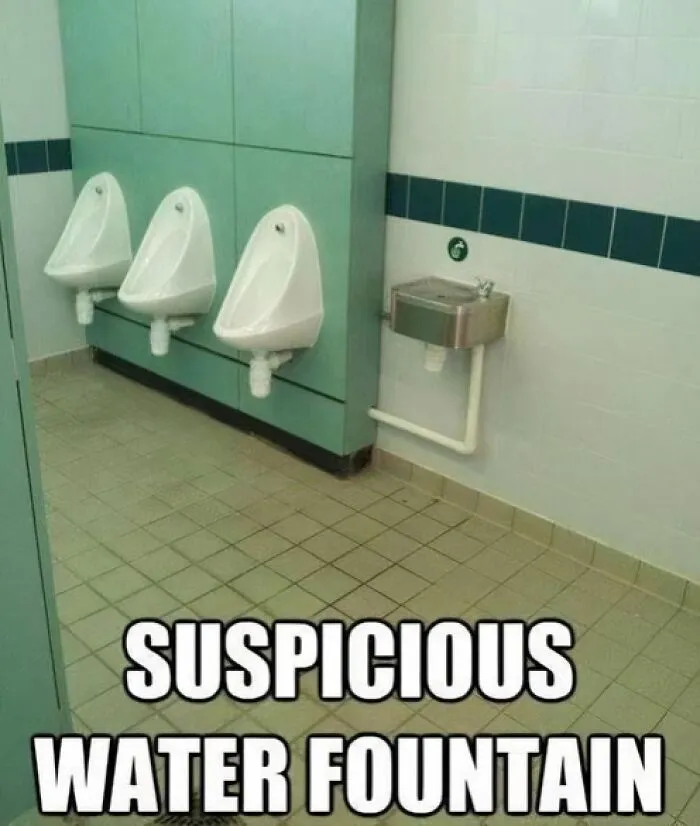 Funny cringe construction fail showing a water fountain installed directly next to bathroom urinals