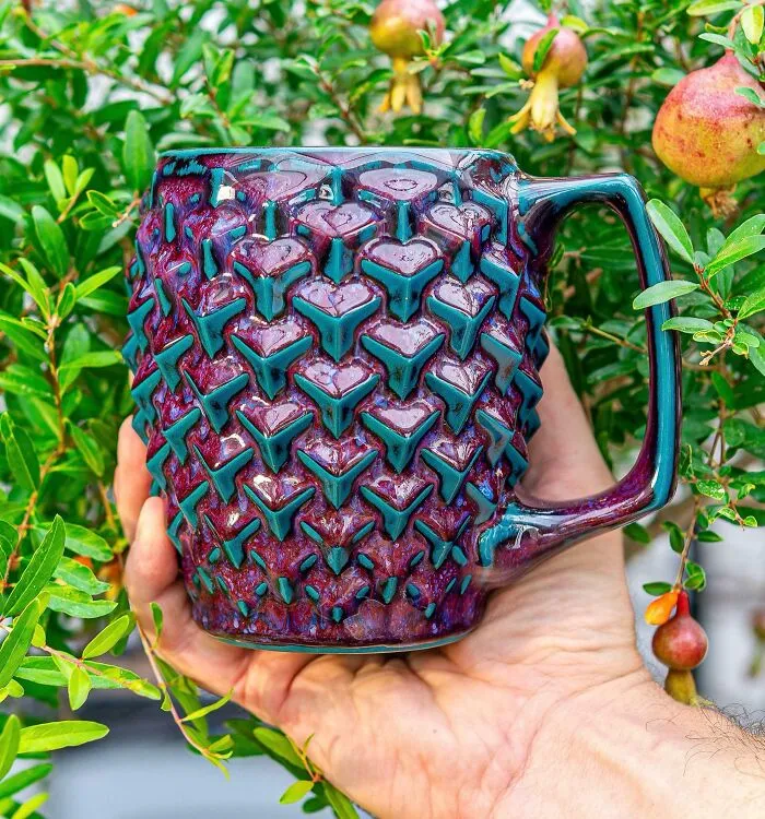 Textured purple and teal ceramic mug showcasing pottery creations.
