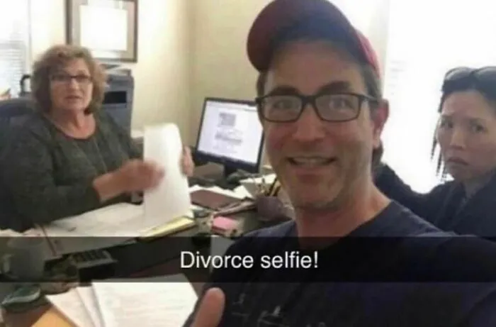 A man taking a cheerful selfie in a lawyer office with the text Divorce selfie, funny memes