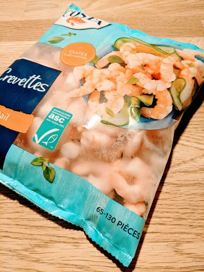Frosty bag of frozen shrimp showing packaging fails with misprinted text or labels