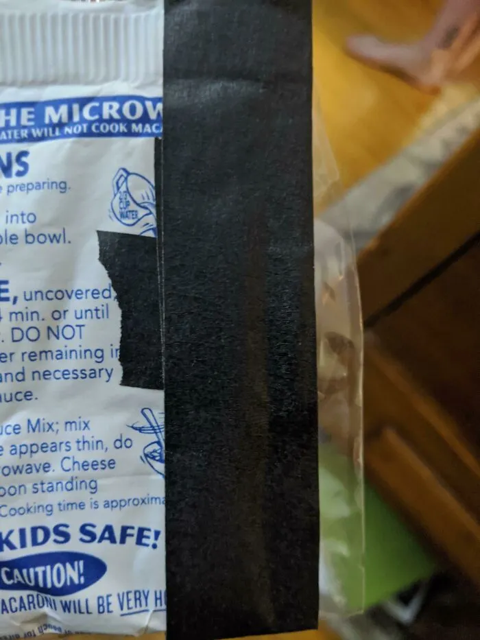 Close up of food label with black tape covering instructions as a packaging fail