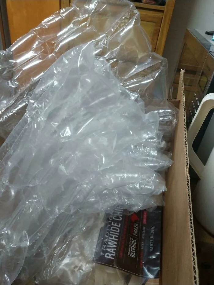 Cardboard box filled with excessive plastic bubble wrap as a bad packaging fail example