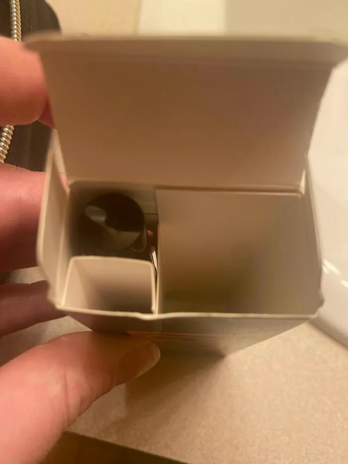 Mostly empty product box with a large internal divider holding a small item, reflecting bad packaging fails.