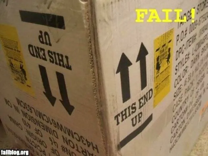 Cardboard shipping box with upside-down 'This End Up' labels, showing bad packaging fails.
