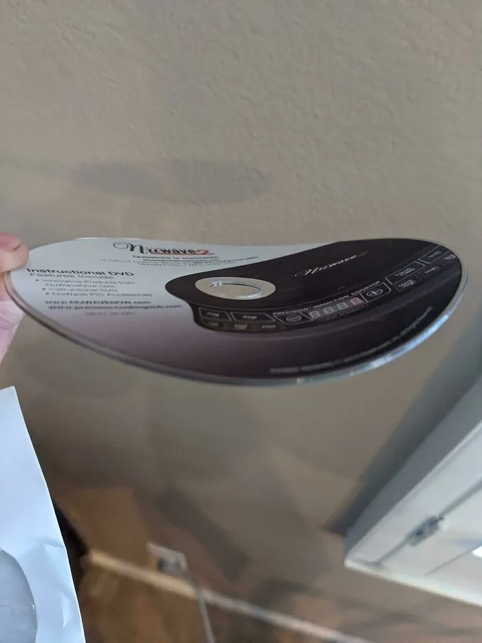 A warped and bent instructional DVD showing bad packaging fails