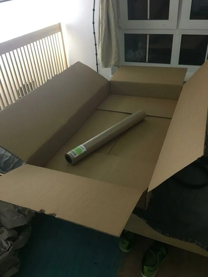 A single cardboard tube placed inside a massive empty box illustrating bad packaging fails.