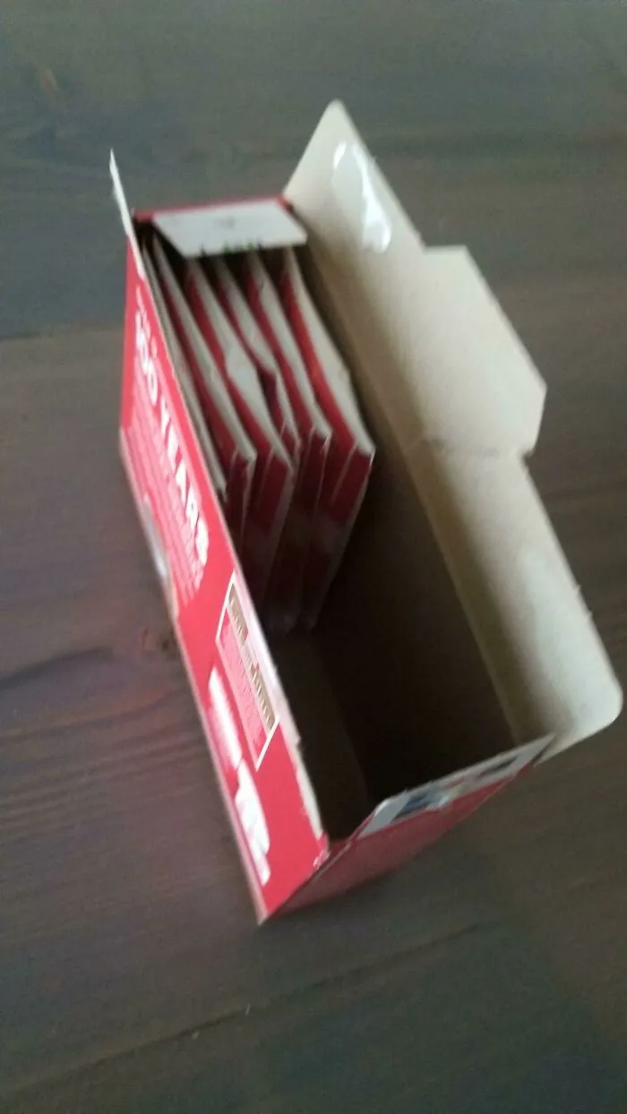 Cardboard box mostly empty with only a few thin packets demonstrating packaging fails