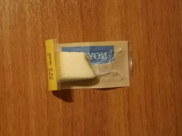 A tiny piece of cheese sealed in a giant plastic wrapper, showcasing excessive packaging fails.