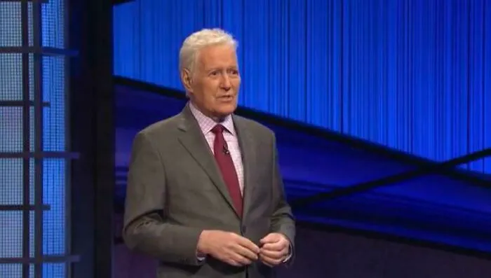 Alex Trebek standing on the Jeopardy game show set, captured in photos for the last time as a host