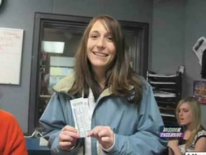 Smiling woman holding tickets captured in photos for the last time