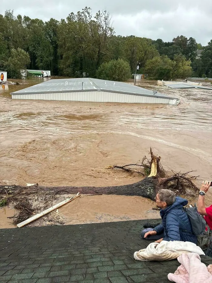 People watching floodwaters submerge buildings, one of many captured in photos for the last time.