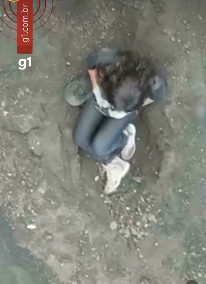 Overhead view of a person captured in photos for the last time sitting on dusty ground.