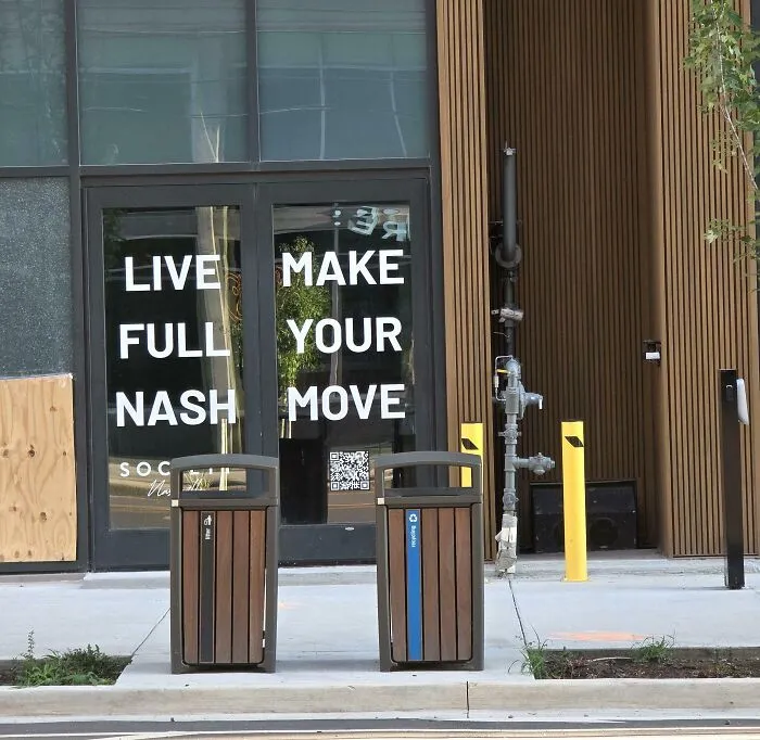 A terribly designed sign on glass doors with confusing layout reading Live Full Nash Make Your Move