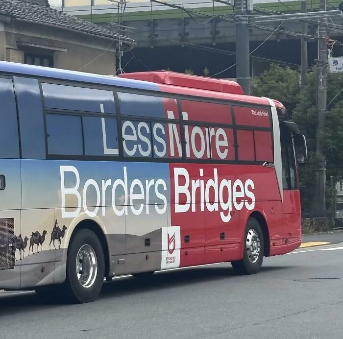 A red and blue bus with confusing text formatting showcasing terribly designed signs.