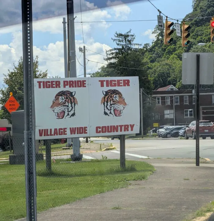A roadside sign with confusing tiger mascot text, demonstrating terribly designed signs.
