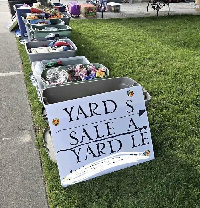 A hand-painted sign for a garage sale with mismatched and confusing word placement, an example of terribly designed signs.