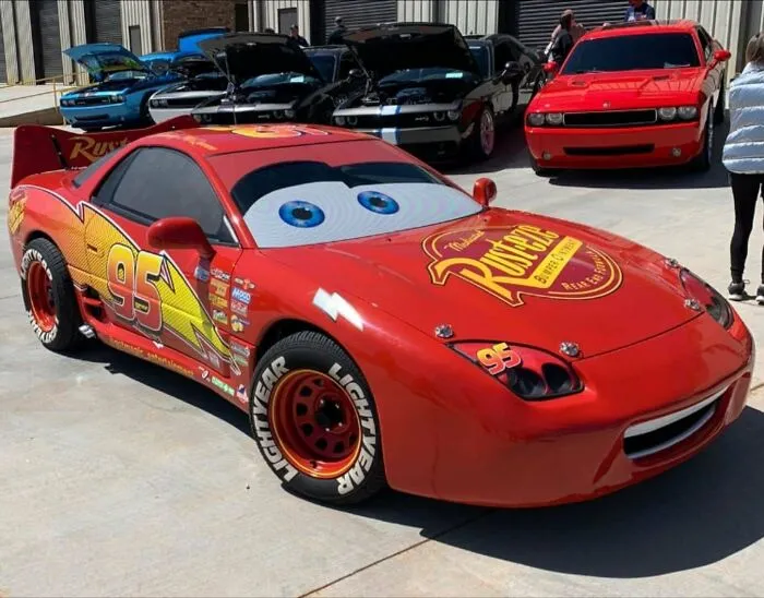 A red Lightning McQueen replica car featured in wholesome pics of dads showing off cool vehicle builds
