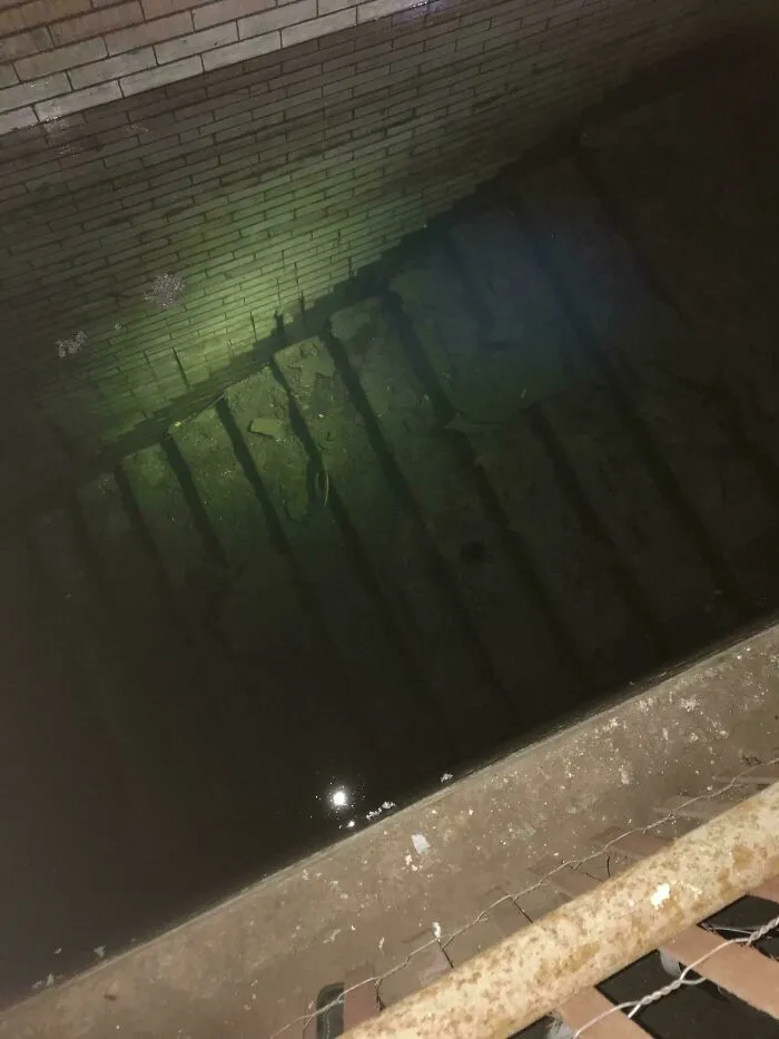 Eerie view of flooded concrete stairs leading deep underwater, demonstrating why people fear submerged objects.