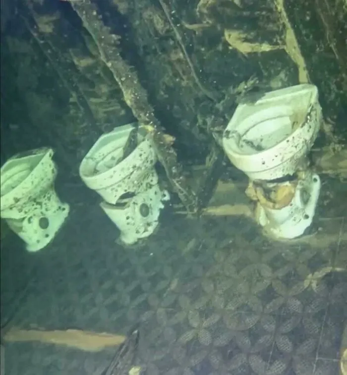 Eerie view of toilets submerged underwater on a sunken ship wreck.
