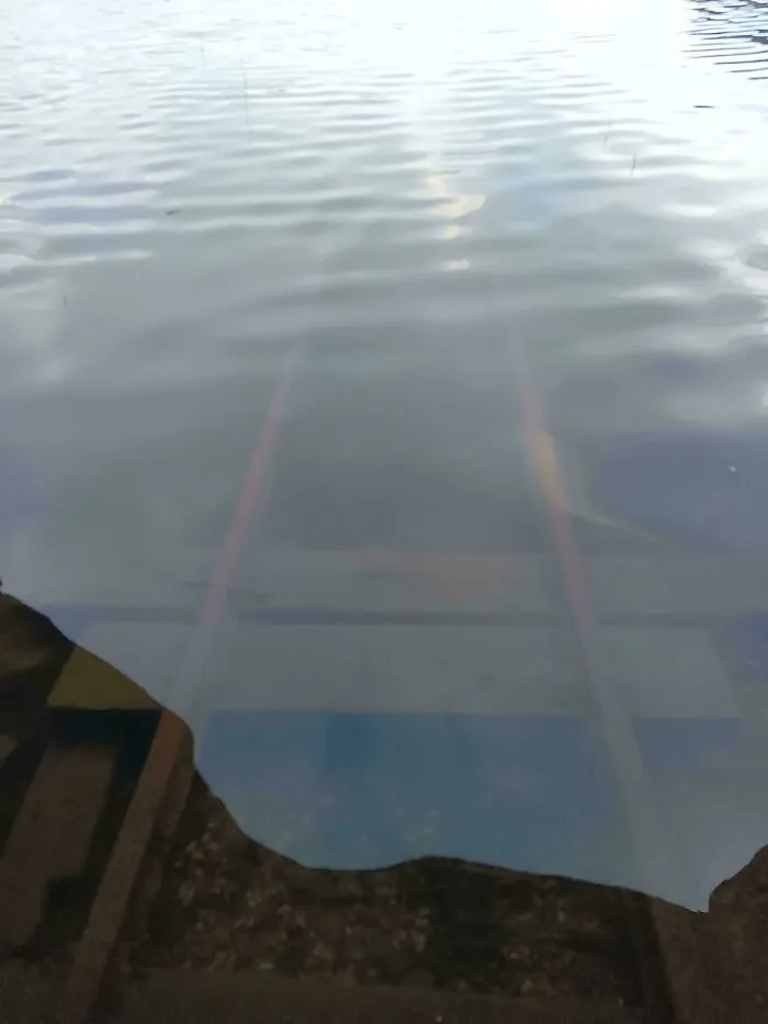 Submerged objects including wooden tracks leading down into murky water.