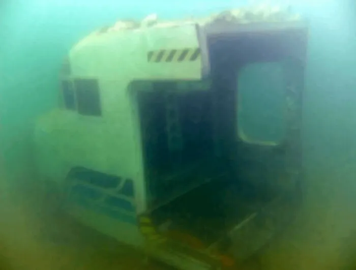 Unnerving sunken airplane cockpit, one of many submerged objects underwater.