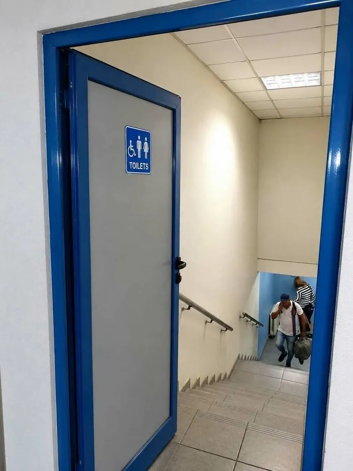 A toilet door opening directly over a steep staircase illustrating major construction fails.