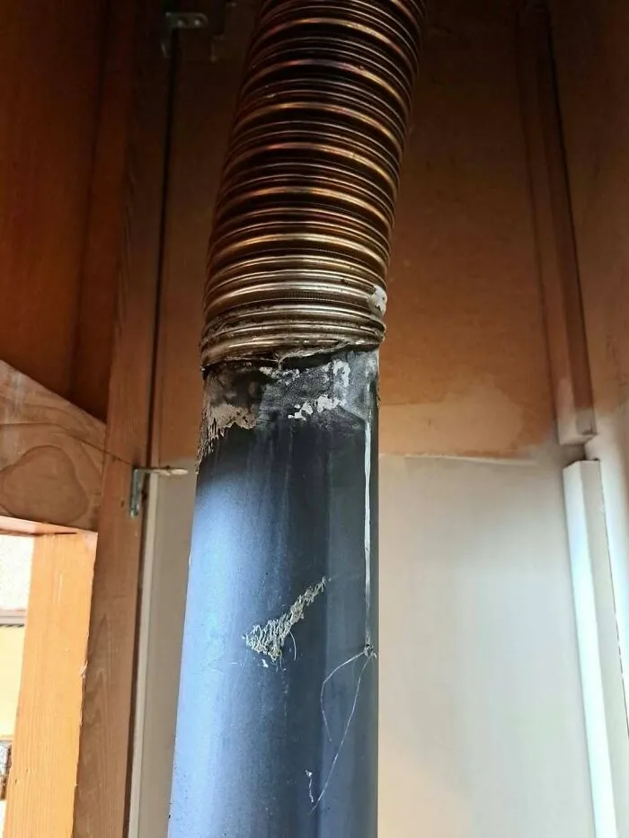 A poorly fitted exhaust pipe taped together, showcasing a construction fail.
