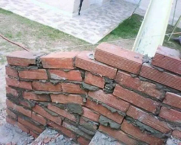 A crookedly laid brick wall showing an obvious construction fail.