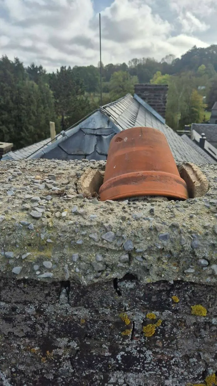 Clay flower pot used as a chimney cap showing construction fails