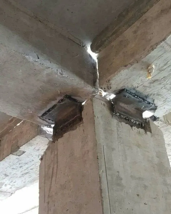 Unsafe support column barely holding up concrete beams, an example of poor construction fails.
