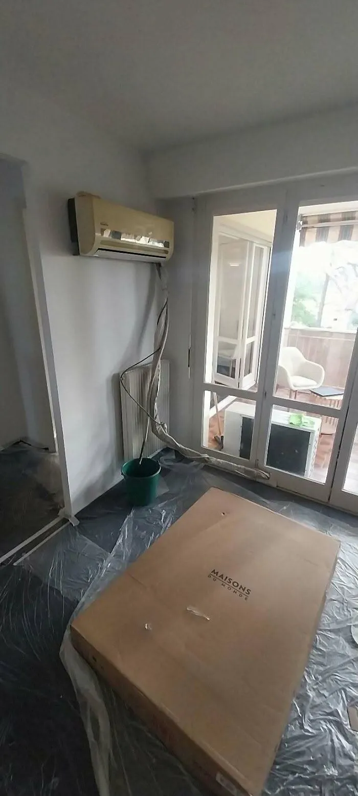 An air conditioning unit poorly installed with hanging hoses, demonstrating a hilarious construction fail.