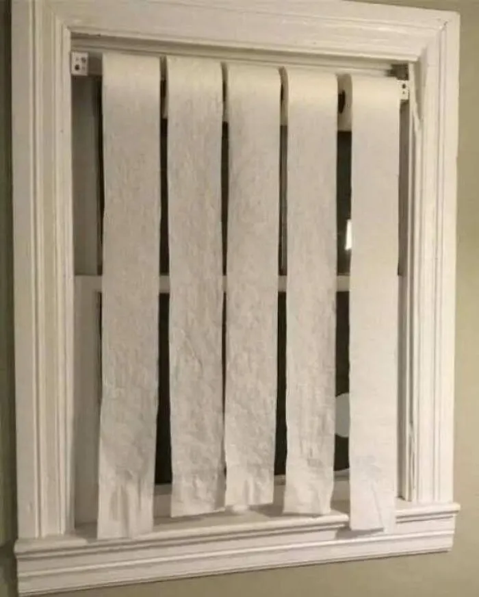 Window covered with unrolled toilet paper used as makeshift blinds, an amusing construction fail.