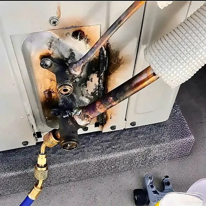 Burned copper HVAC pipes showing severe construction fails during AC unit installation work.
