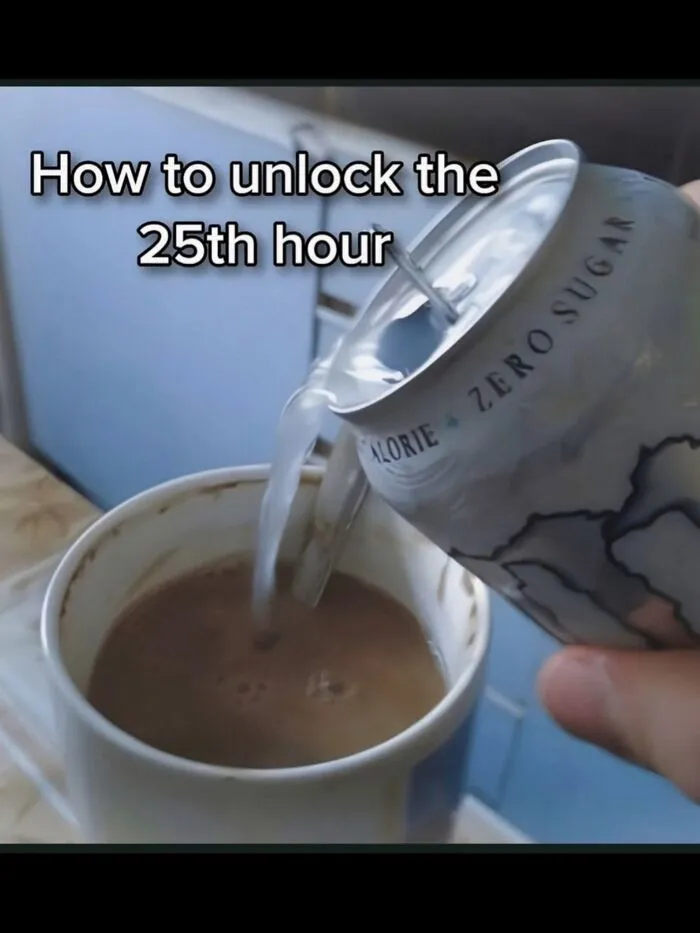 Hand pouring energy drink into a mug of coffee, reflecting hilarious memes about daily struggles.
