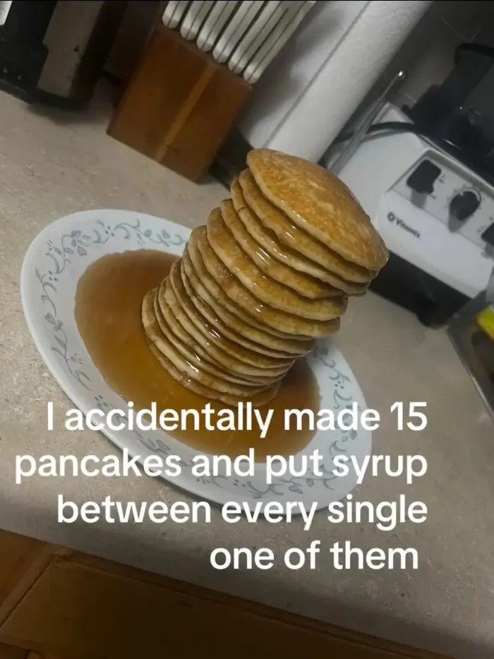 A tall stack of pancakes swimming in syrup, an example of hilarious memes showing relatable food mishaps.