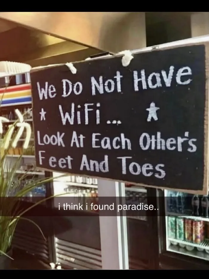 A hilarious meme showing a sign that says We Do Not Have WiFi Look At Each Other's Feet And Toes