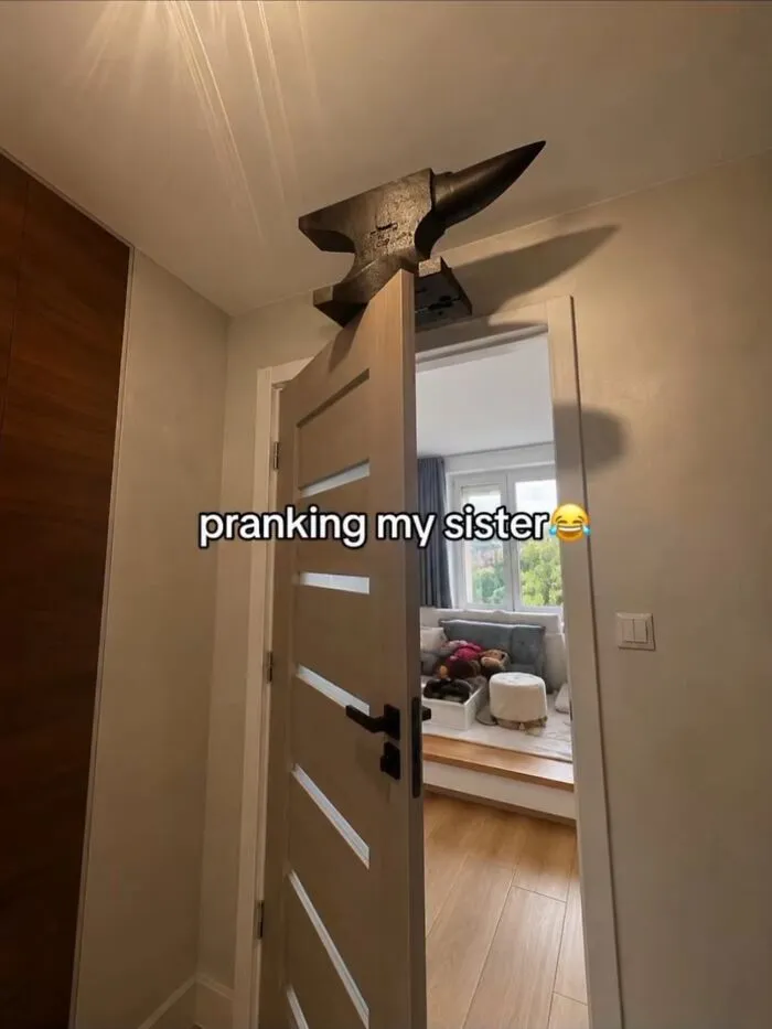 Dangerous prank setup with a heavy metal anvil balanced on an open door frame