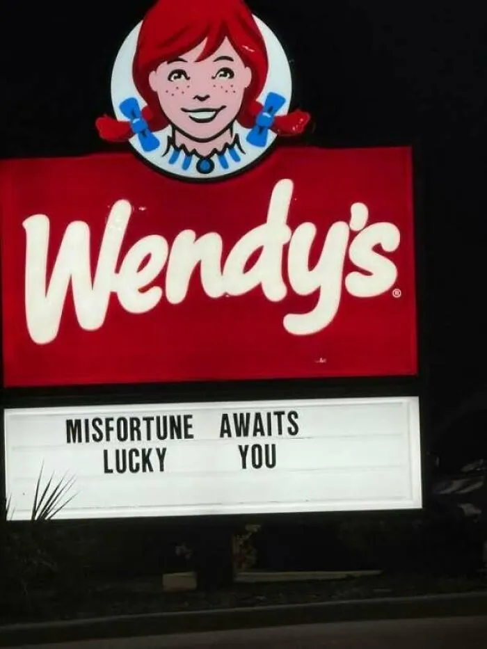 Hilarious signs: a Wendy's fast food sign with a confusingly arranged message reading Misfortune Awaits Lucky You.