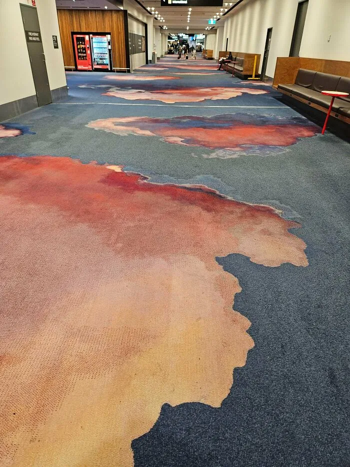 Airport carpet with messy reddish stains resembling blood patches