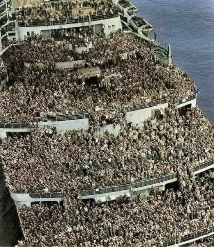 Overcrowded historic ship filled with people densely packed on the deck