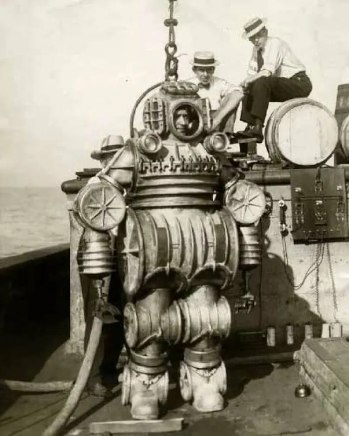 Early deep sea diving suit with divers on boat vintage history