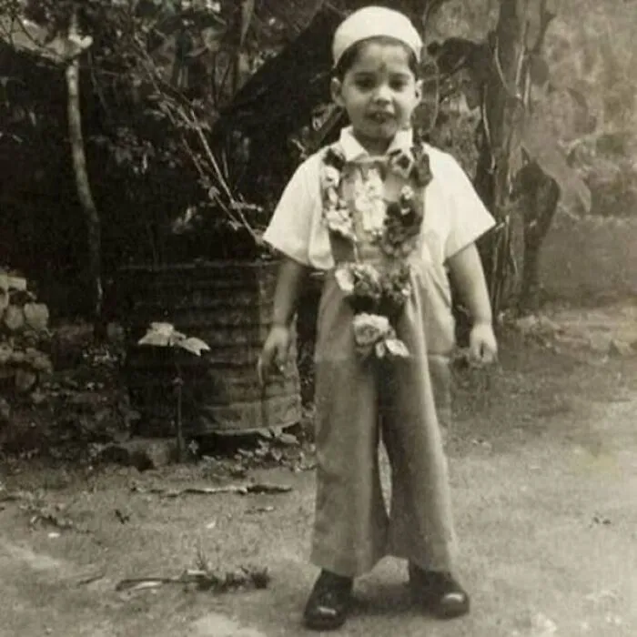 Vintage black and white photo of a child dressed in old-fashioned clothes