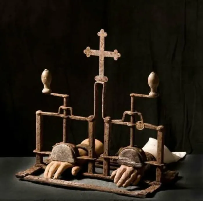 Historical torture device with a cross and iron clamps for hands