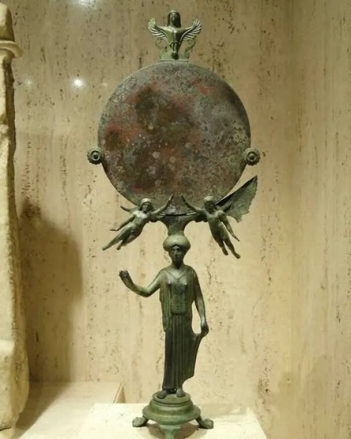 Antique bronze mirror with winged figures and standing female statue