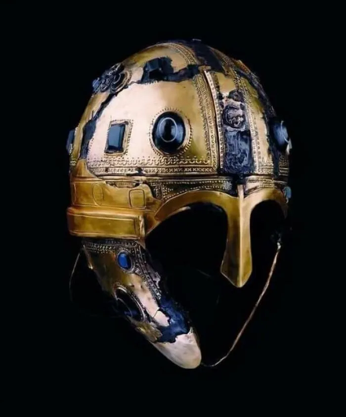 Ancient decorated golden helmet with blue details on black background